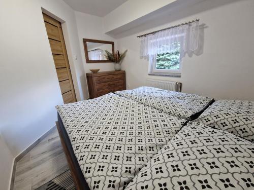 斯姆爾克山麓新城的住宿－Restaurace U Matěje B&B，一间卧室配有一张带黑白色棉被的床
