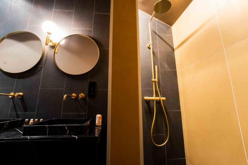 un bagno con due specchi, lavandino e doccia di Luxury Penthouse & Terrace - Mons City Center a Mons