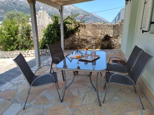 un patio con mesa y 4 sillas en Sweet home of Kefalonia, en Agia Efimia