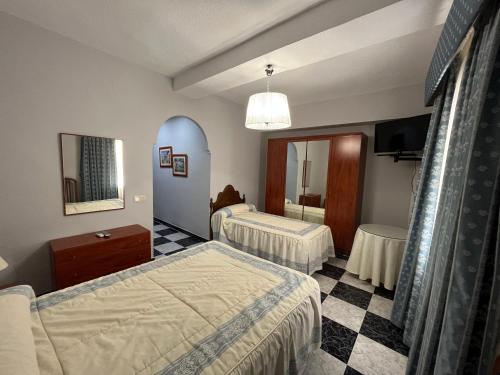 Hotel Plaza Damasco في المونيكار: غرفة فندقية بسريرين ومرآة