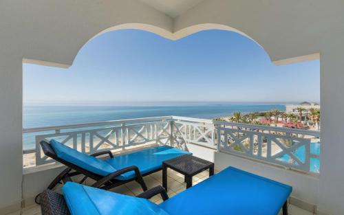a balcony with a table and chairs and the ocean at Radisson Blu Resort & Thalasso Hammamet in Hammamet