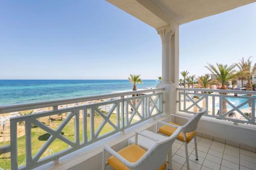a balcony with chairs and a view of the beach at Radisson Blu Resort & Thalasso Hammamet in Hammamet