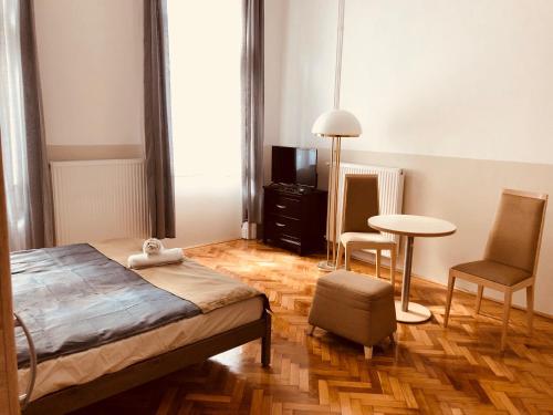 ブダペストにあるDowntown Apartmentのベッドルーム1室(ベッド1台、テーブル、椅子付)