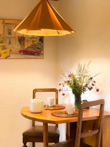 a wooden table with a vase of flowers on it at Tobishirdgård in Simrishamn