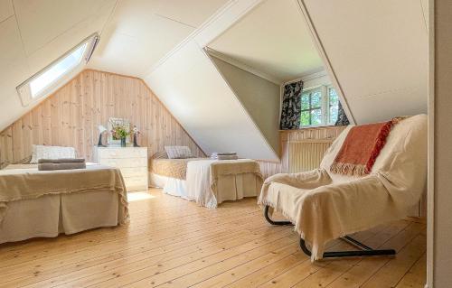 Zimmer im Dachgeschoss mit 2 Betten und einem Stuhl in der Unterkunft Tobishirdgård in Simrishamn