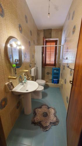 a bathroom with a sink and a toilet and a mirror at Appartamento spazioso e fresco in punto strategico. in Castellammare del Golfo