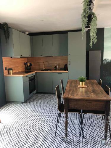 - une cuisine avec une table et des chaises en bois dans la chambre dans l'établissement La Sodilie proche centre ville au calme Parking gratuit, à Nantes