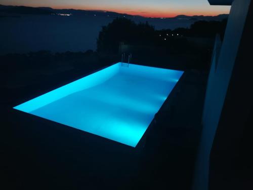 una luce blu sul tetto di una casa di notte di Villa Harmonia a Città di Egina