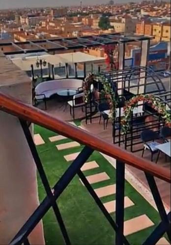 a balcony with tables and chairs on a building at لؤلؤة الشرق للشقق المخدومة Luluat Al sharq For Serviced Apartment in Hafr Al Baten