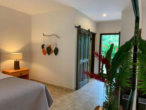 a bedroom with a bed and a plant in a vase at Natural Lodge Caño Negro in Caño Negro