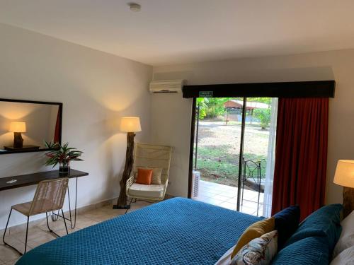 - une chambre avec un lit et une porte coulissante en verre dans l'établissement Natural Lodge Caño Negro, à Caño Negro