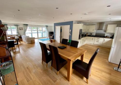a kitchen and living room with a wooden table and chairs at Tamar View in Plymouth