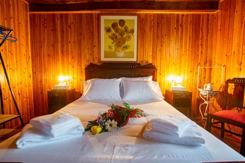 ein Schlafzimmer mit einem Bett mit Blumen und Handtüchern in der Unterkunft Aurora House in Mosteiros