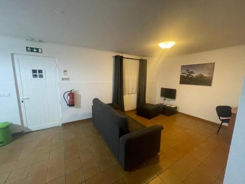 a living room with a couch and a television at Casas do Verdelho in Madalena