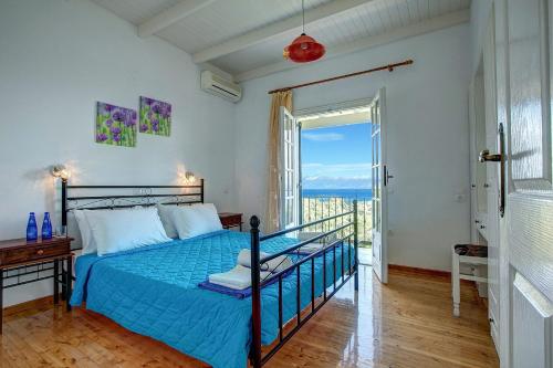 a bedroom with a bed with a view of the ocean at Villa Caribia by Villa Plus in Ágios Stéfanos