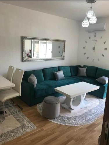 a living room with a green couch and a table at KENZA jednosobni stanovi in Podgorica