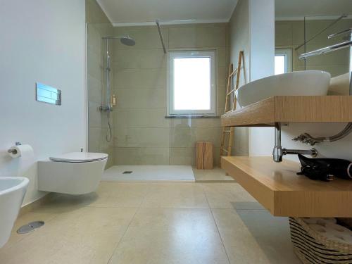 W łazience znajduje się toaleta, umywalka i prysznic. w obiekcie Samoqueira 12 w mieście Porto Covo