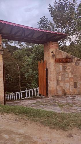 a building with a wooden door and a gate at Finca Campestre Rancho Alegre in Fusagasuga