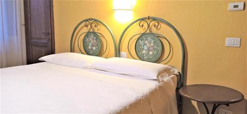 a bedroom with a white bed and a table at CAMPO AL VENTO - Country farm in Monte Castello di Vibio