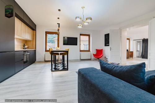 un soggiorno con divano blu e una cucina di Sierra - Northstar Apartments a Braşov