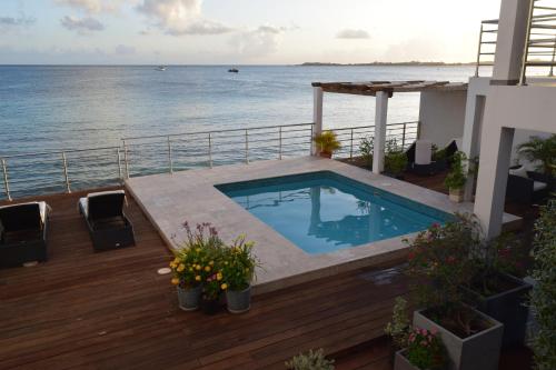 a swimming pool on the deck of a house overlooking the ocean at Tradewinds Apartments Simpson Bay in Simpson Bay