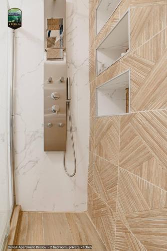 a bathroom with a shower with a wooden wall at Sierra - Northstar Apartments in Braşov