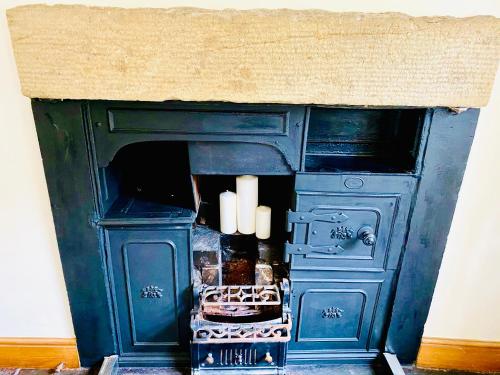 a blue stove with white candles in a room at The Old Post Office - Giggleswick in Giggleswick