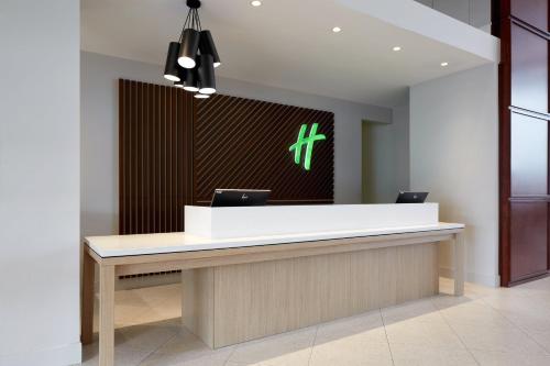 a reception desk in a office with a cross on the wall at Holiday Inn & Suites Montreal Airport by IHG in Dorval