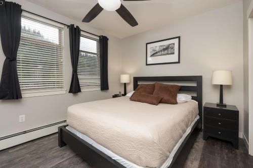 een slaapkamer met een bed en twee ramen bij Founders 2 Bedroom Condo in Winter Park