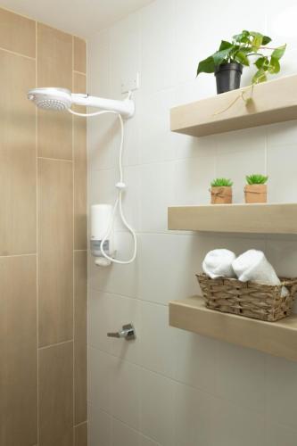 a bathroom with a shower with shelves and towels at Silver Sun Apartment in Guatemala