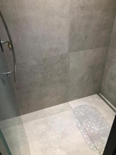 a shower with a glass door and a shower at FLAT BEIRA MAR BARRA DE JANGADA ANDAR ALTO JABOATão in Recife