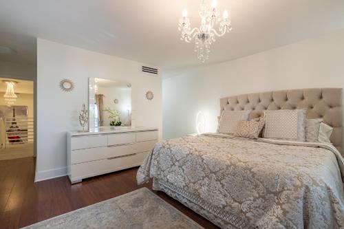 een slaapkamer met een groot bed en een kroonluchter bij Luxurious and cozy Townhouse 3 bedrooms 2.5 Bath in Miami