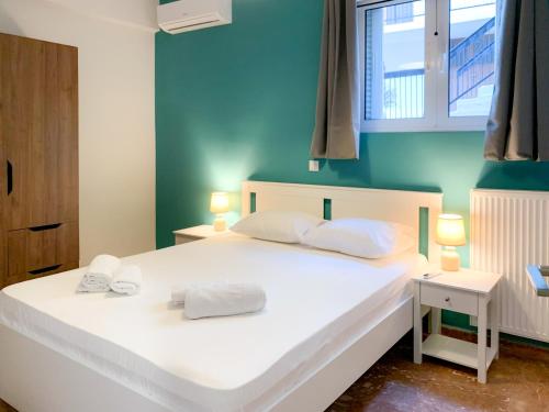 - une chambre avec un lit blanc et 2 serviettes dans l'établissement Nyx Apartments, à Ancient Epidavros
