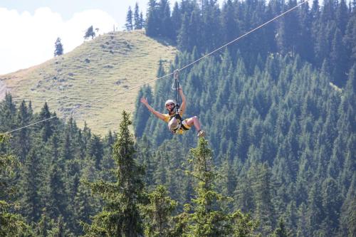 a person is hanging on a rope on a zip line at Alpenrose Appartements in Nesselwang