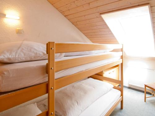 2 Etagenbetten in einem Zimmer mit Fenster in der Unterkunft Landhaus am Breitenberg in Pfronten