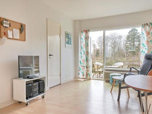 a living room with a tv and a table at 2 person holiday home in Aakirkeby-By Traum in Vester Sømarken