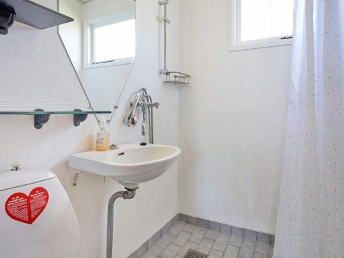 a white bathroom with a sink and a toilet at Holiday home Aakirkeby XXVII in Vester Sømarken
