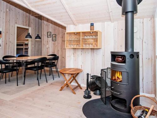a fireplace in a room with a table and chairs at 6 person holiday home in Hemmet-By Traum in Hemmet
