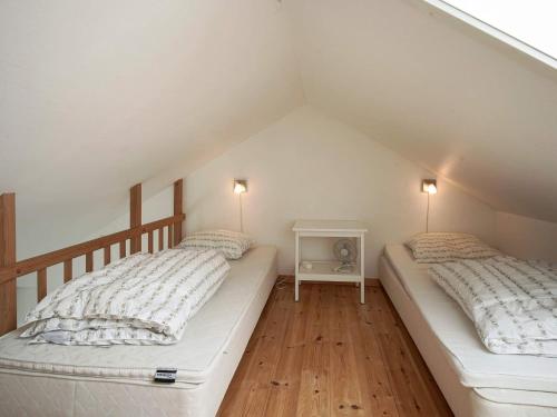 two beds in a attic room with two lamps at Seaside Property in Sandkas in Allinge