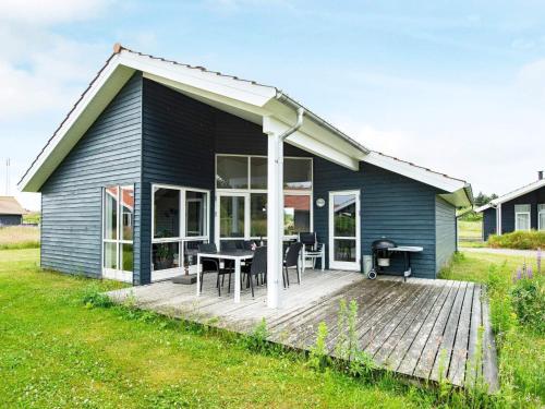 Fjand Gårdeにある8 person holiday home in Ulfborgのブルーハウス デッキ&テーブル付