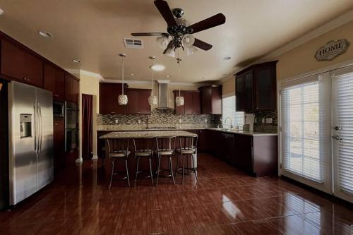 una cocina con ventilador de techo y electrodomésticos de acero inoxidable en HUGE GORGEOUS UPGRADED HOME IN THE CENTER OF SOCAL, en Loma Linda