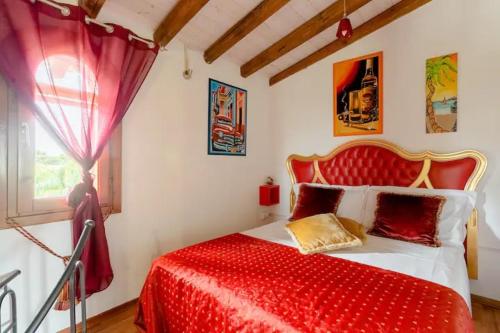 1 dormitorio con cama roja y ventana en Casa vacanza Cristina, en Plemmirio