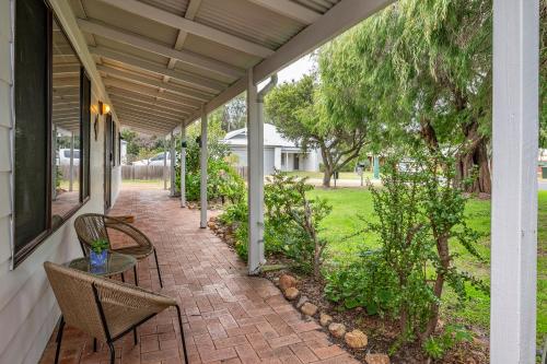 un patio con tavolo e sedie in una casa di Menta Cottage a Dunsborough