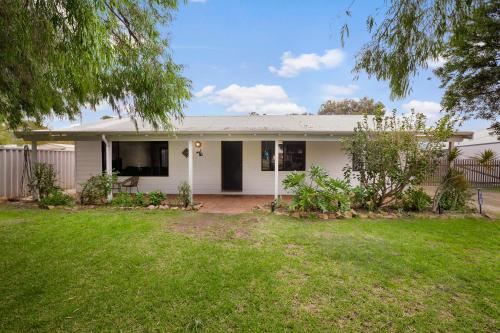 a white house with a fence and a yard at Menta Cottage in Dunsborough
