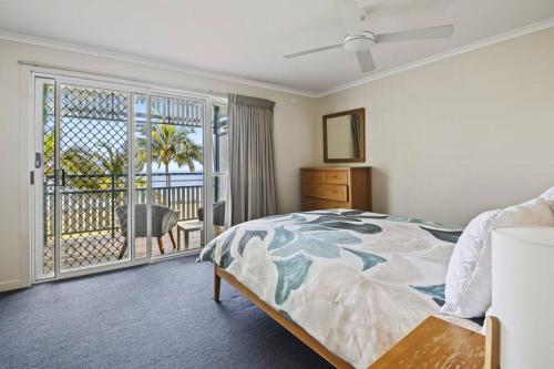 The Sunsetter - Villa 25 Tangalooma في تنجالوما: غرفة نوم بسرير وشرفة
