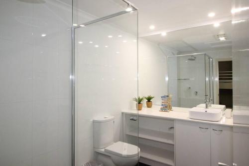 天閣露瑪的住宿－The Sunsetter - Villa 25 Tangalooma，一间带卫生间、水槽和镜子的浴室