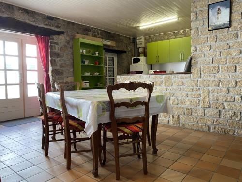 uma cozinha com uma mesa com cadeiras e armários verdes em Maison Étel, 3 pièces, 4 personnes - FR-1-397-6 em Étel