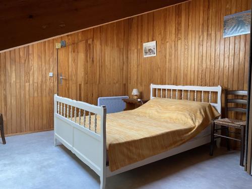 um quarto com uma cama branca e paredes de madeira em Maison Étel, 3 pièces, 4 personnes - FR-1-397-6 em Étel