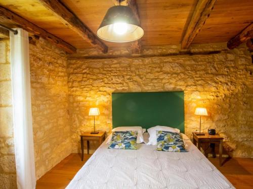 une chambre avec un grand lit dans un mur de pierre dans l'établissement Maison Périgourdine Authentique, 3 Chambres, Jardin, Wifi, Animaux Bienvenus, Proche Salignac-Eyvigues - FR-1-616-152, à Borrèze