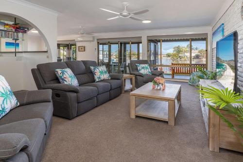 a living room with couches and a coffee table at Waterfront on Forster Keys in Forster